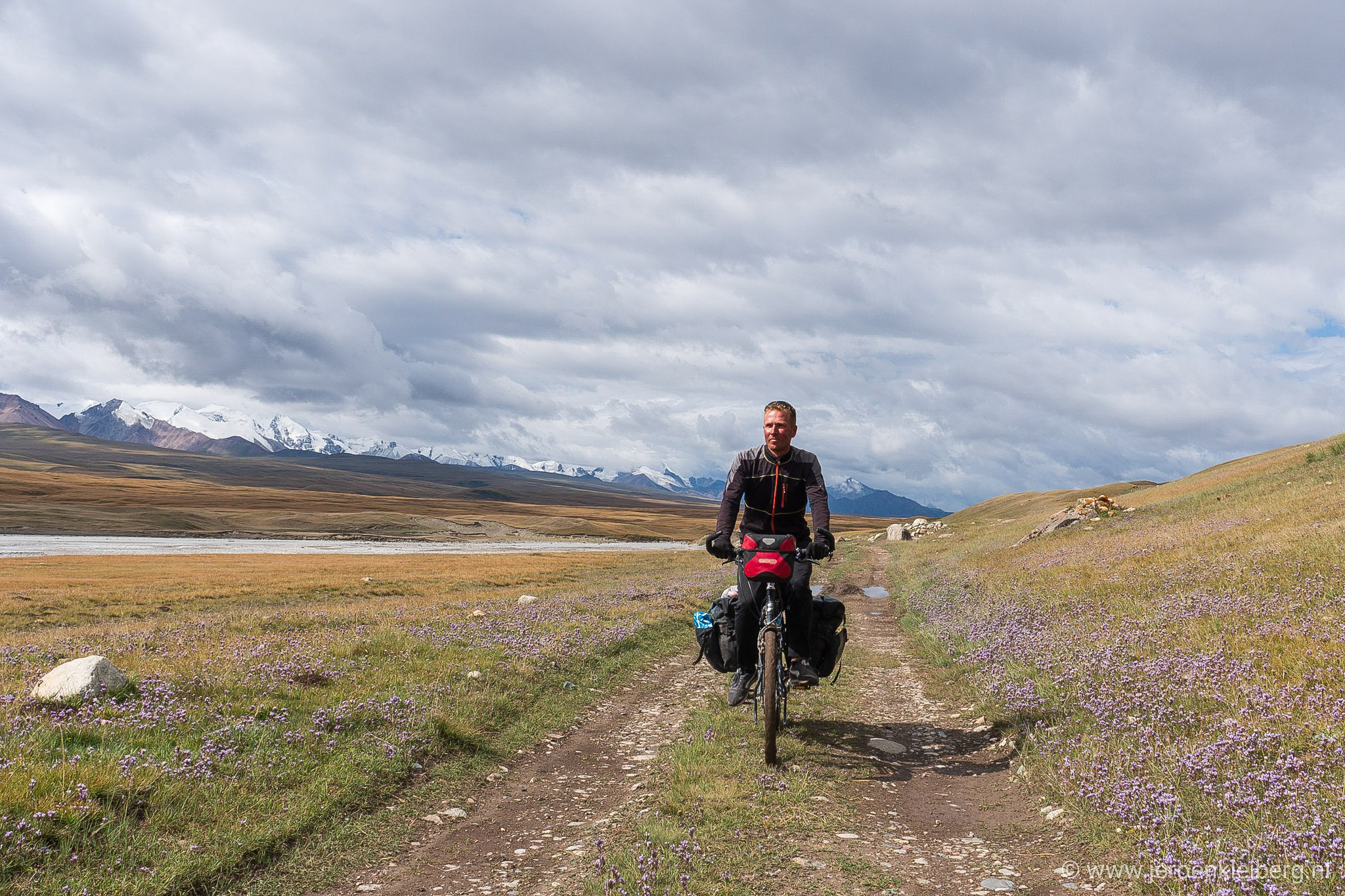 Cyclist on an unpaved road in the Tian Shan Mountains of eastern Kyrgyzstan